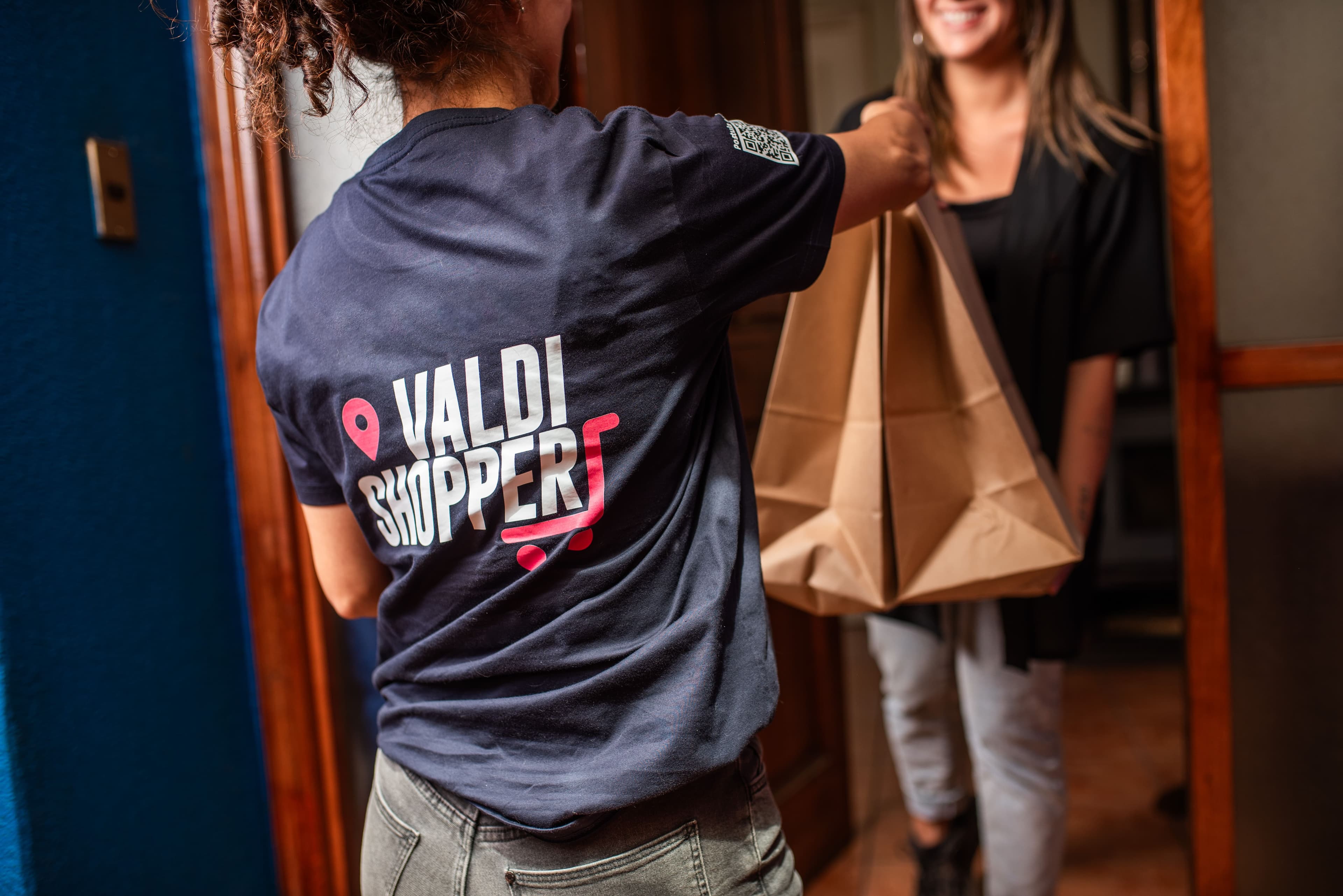 Valdishopper entregando un pedido a una clienta en la puerta de su casa